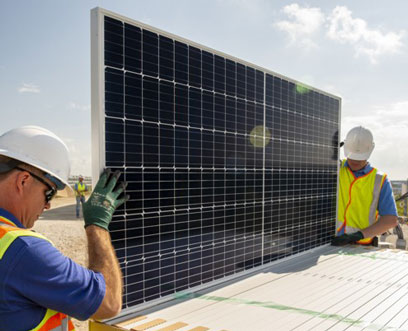 : Employees in a construction site carefully removing solar panels from the box 