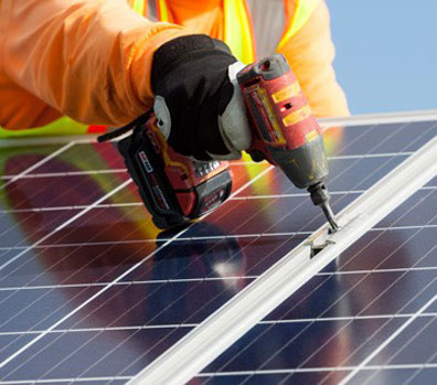 Employee drilling into solar panel.